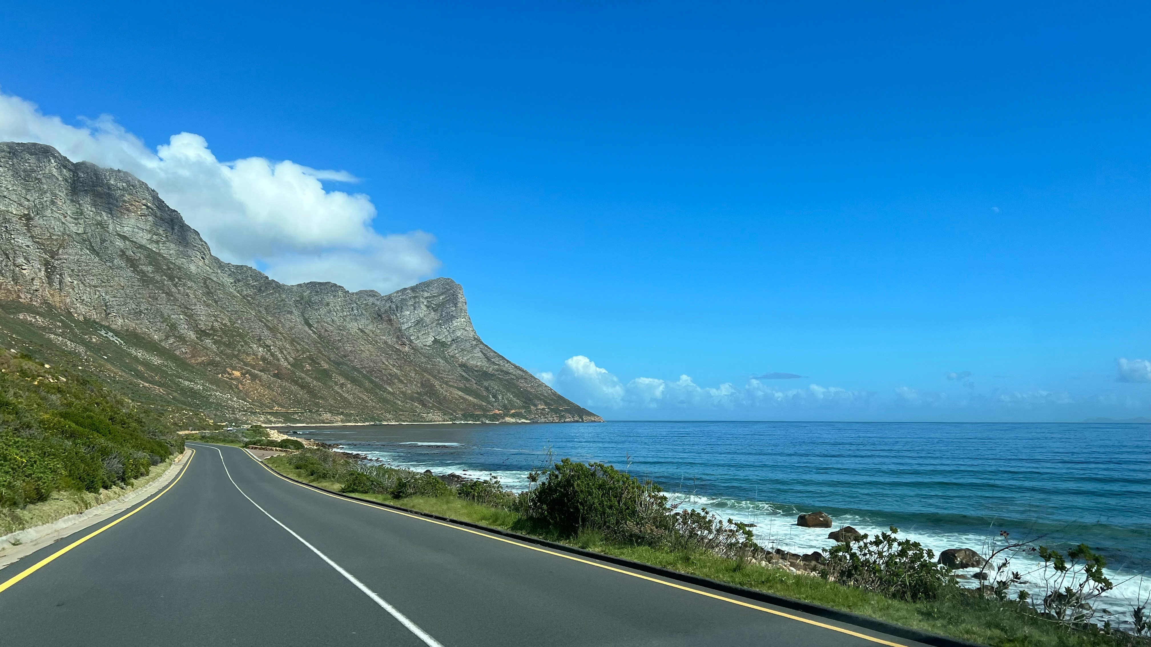 Estrada costeira com oceano e montanhas na África do Sul