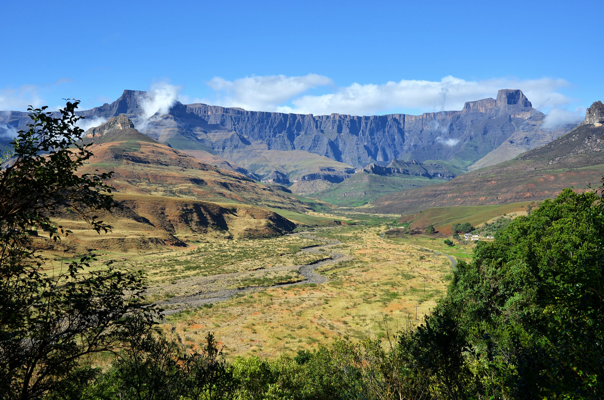 The Amphitheatre long basalt cliff wall rising beyond a green river valley, cloud snagging on the escarpment rim