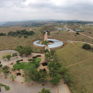 Elevated view of the Maropeng visitor centre complex, its curved walls and access roads set in rolling Highveld grassland