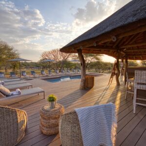 Swimming pool, timber sun deck and thatched bar at Tshukudu Game Lodge